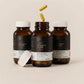 Three bottles of Genetic Labs Berberine supplement with capsules on a beige background